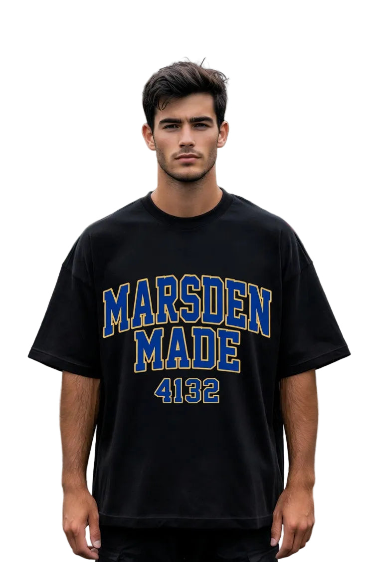 Man wearing a black t-shirt with 'Marsden Made 4132' text standing on a residential street.