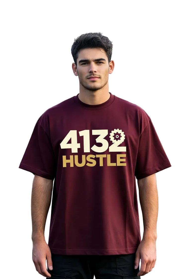 Man wearing a maroon t-shirt with '4132 HUSTLE' printed on it, standing outdoors.