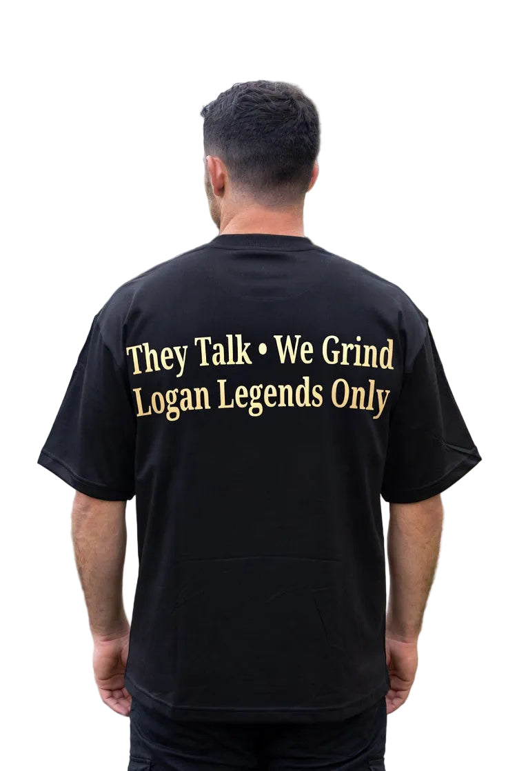 Man wearing a black t-shirt with text on the back, standing on a residential street.